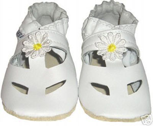 A classy solid white sandal with white trim and yellow centered daisy.